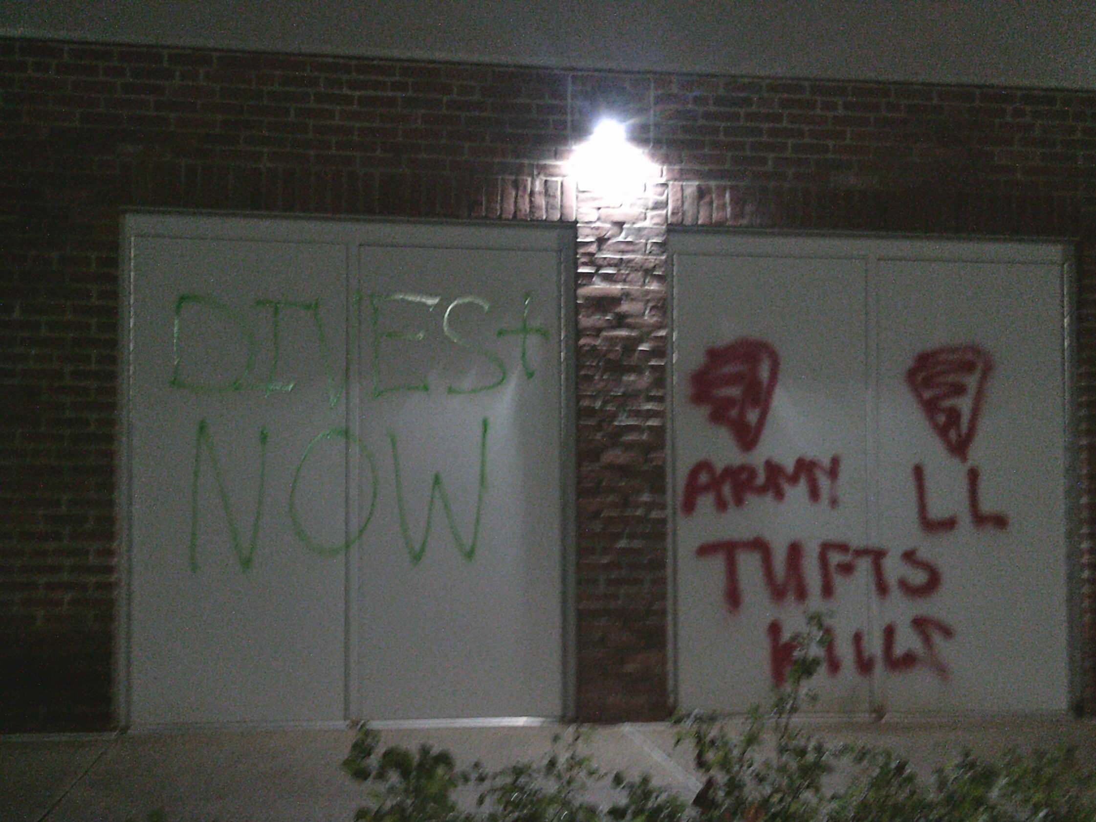 Grafitte stating "Divest Now!" and "Tuft kills"