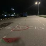 The word "Genocide" with a no symbol over it, and a watermelon below it, graffitied on a street.